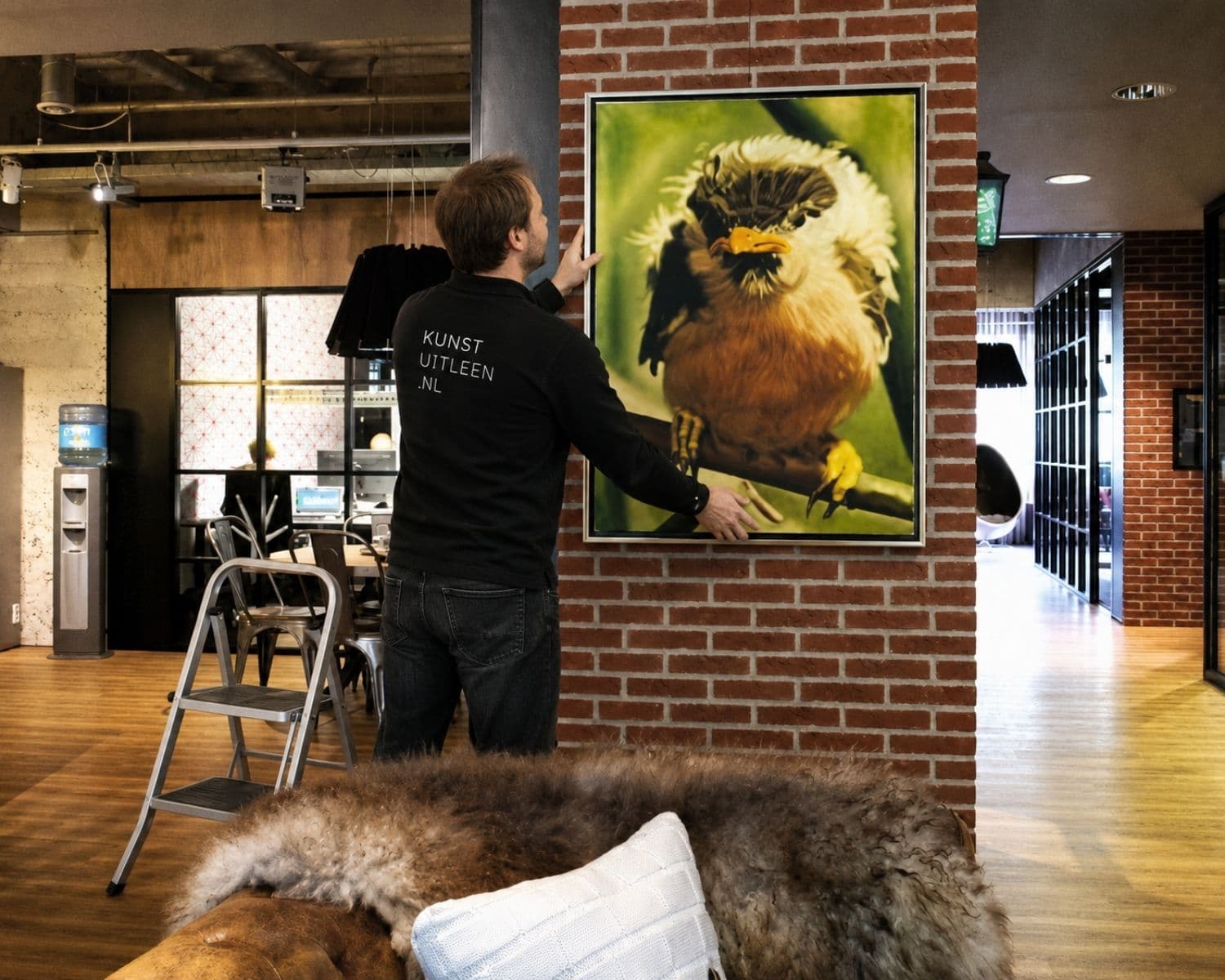 Kunstwerk wordt opgehangen op kantoor